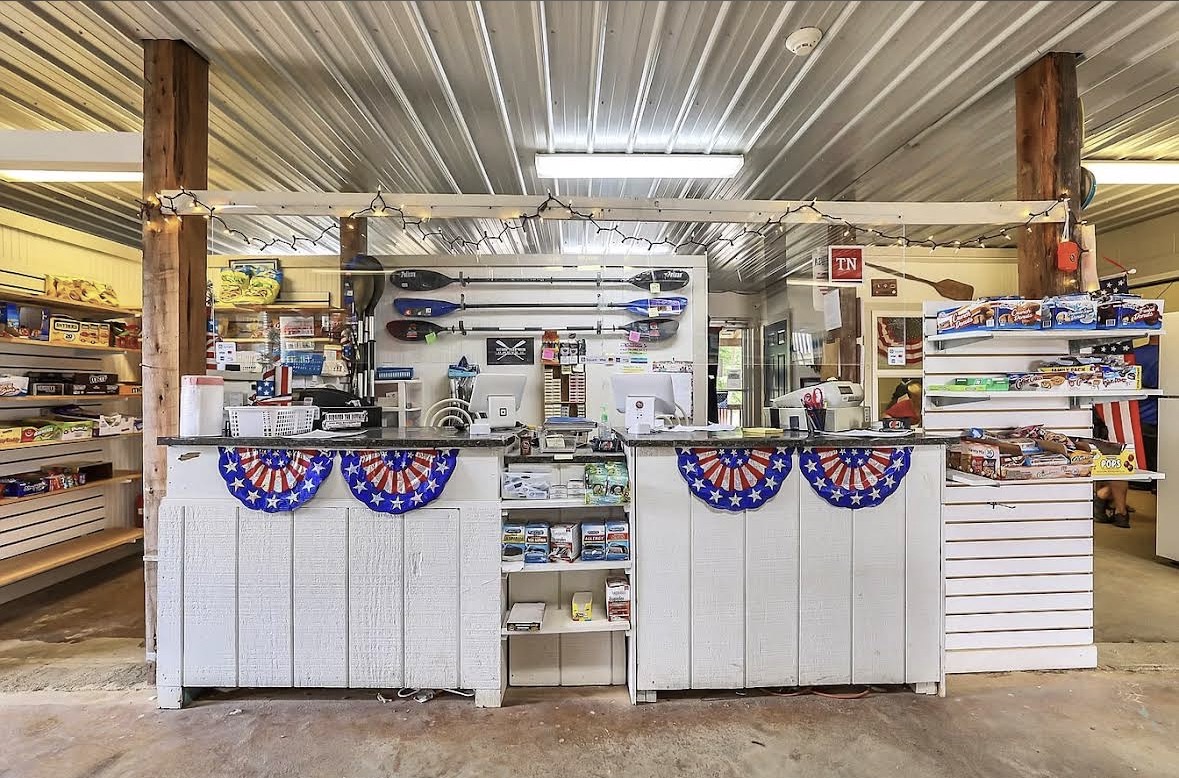 The camp store checkout counter with paddles on the wall