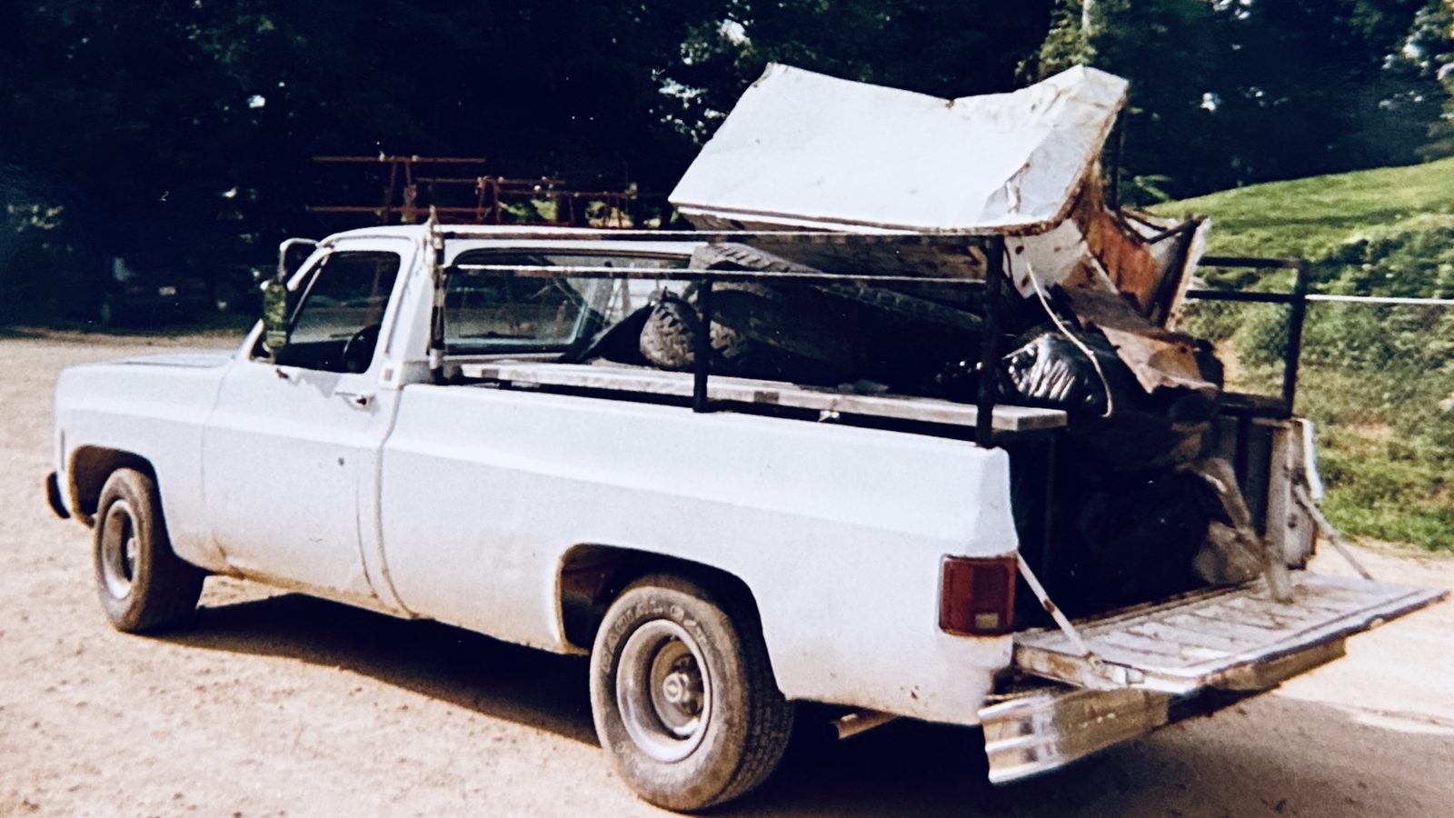 An old white work truck loaded down with lumber and gear at Crazy Horse