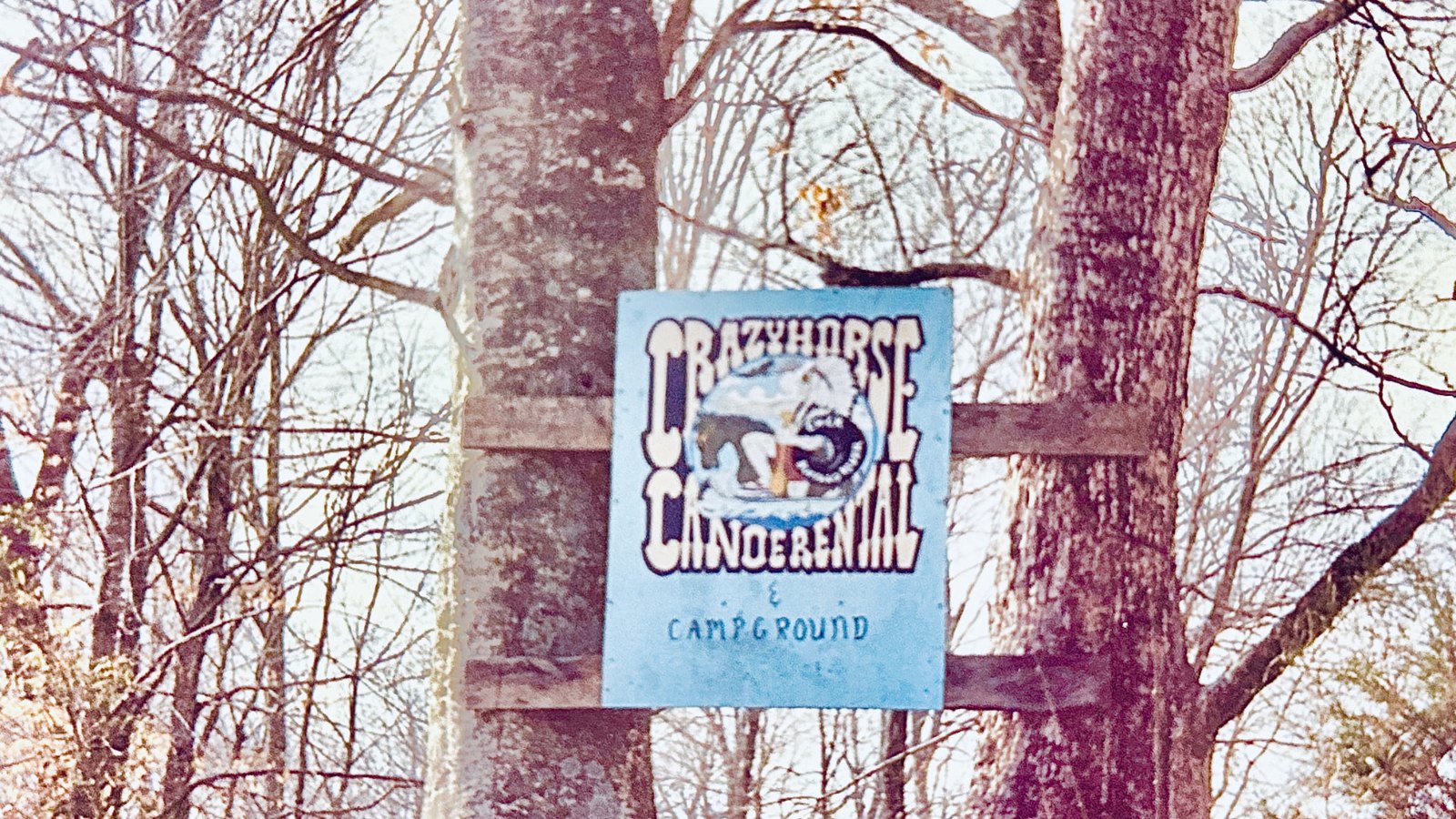 The old hand-painted Crazy Horse Canoe Rental and Campground sign nailed to a tree
