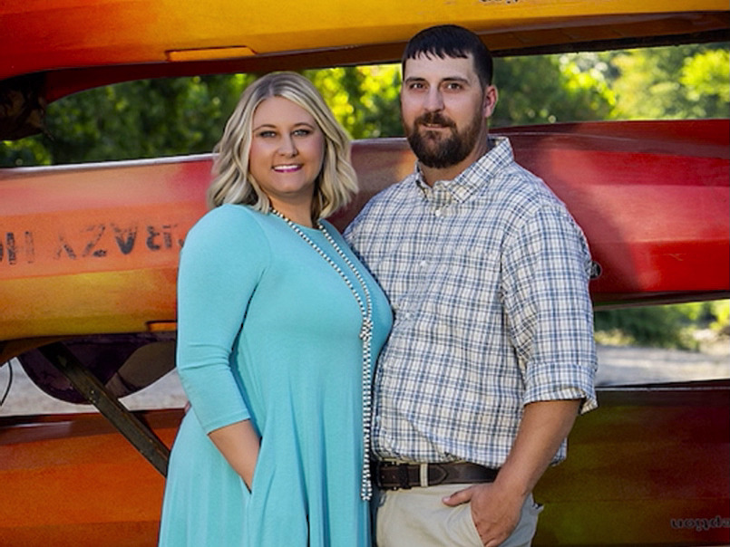 Couple posing in front of the Crazy Horse kayak rack