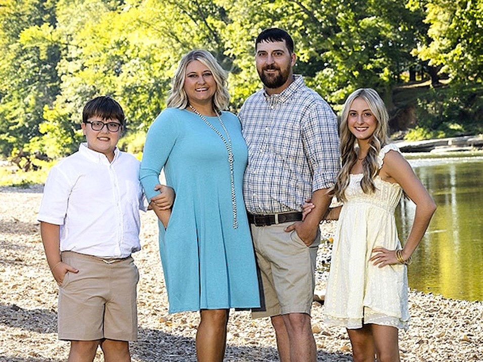 Candi and Jesse Luedeke with their two children on the riverbank