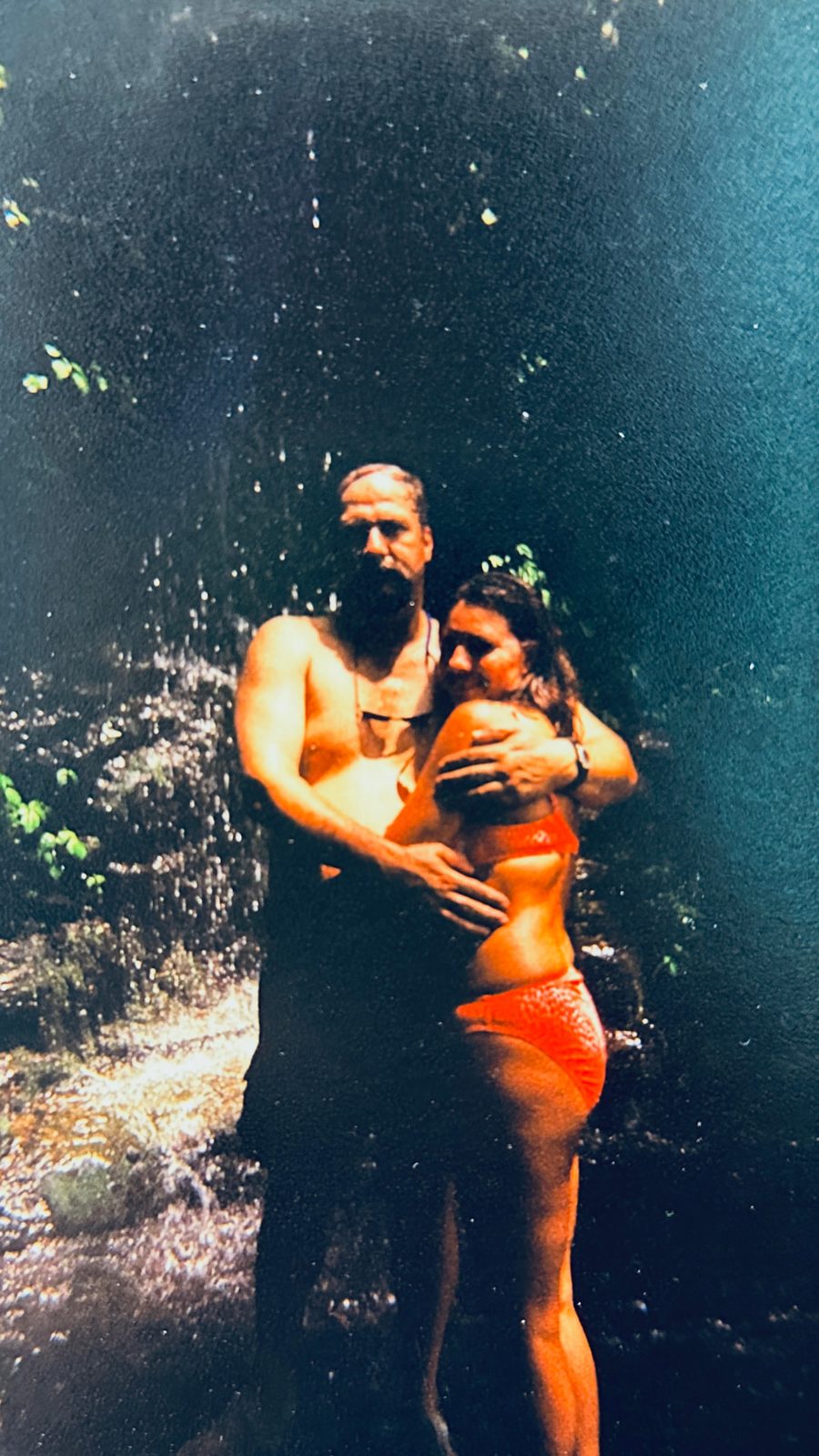 A couple standing together under a waterfall along the Buffalo River