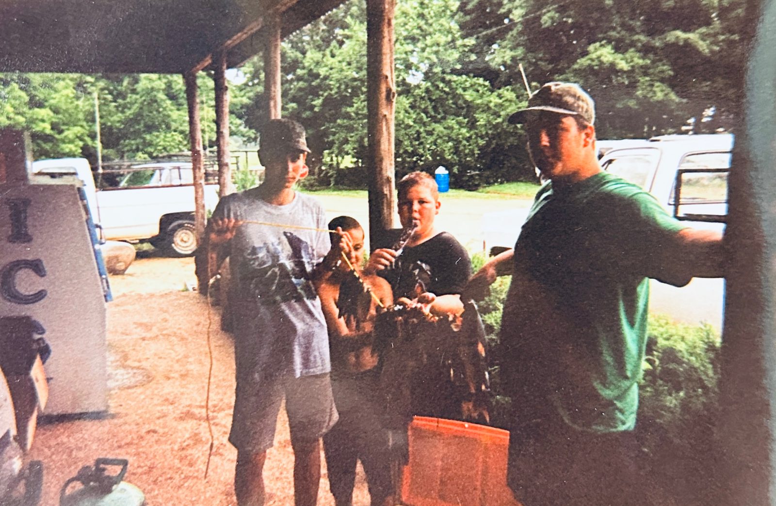Kids and family cleaning fish under the porch of the old camp store