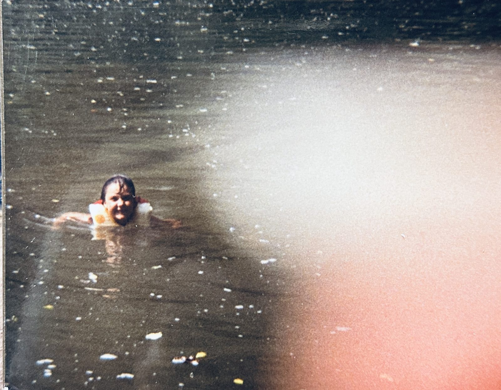 A child swimming in a life jacket in the Buffalo River