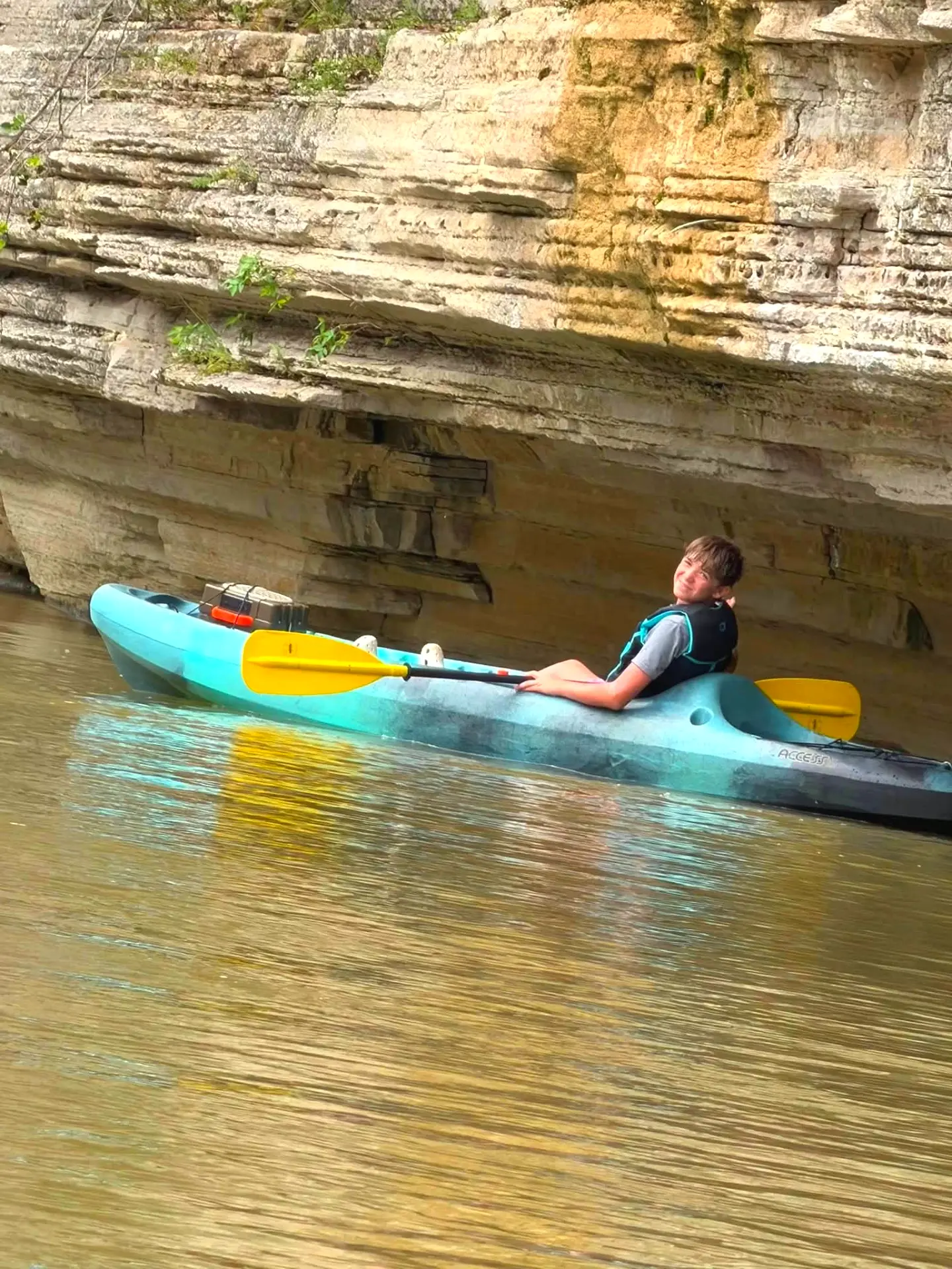 A young paddler resting beside the limestone bluffs