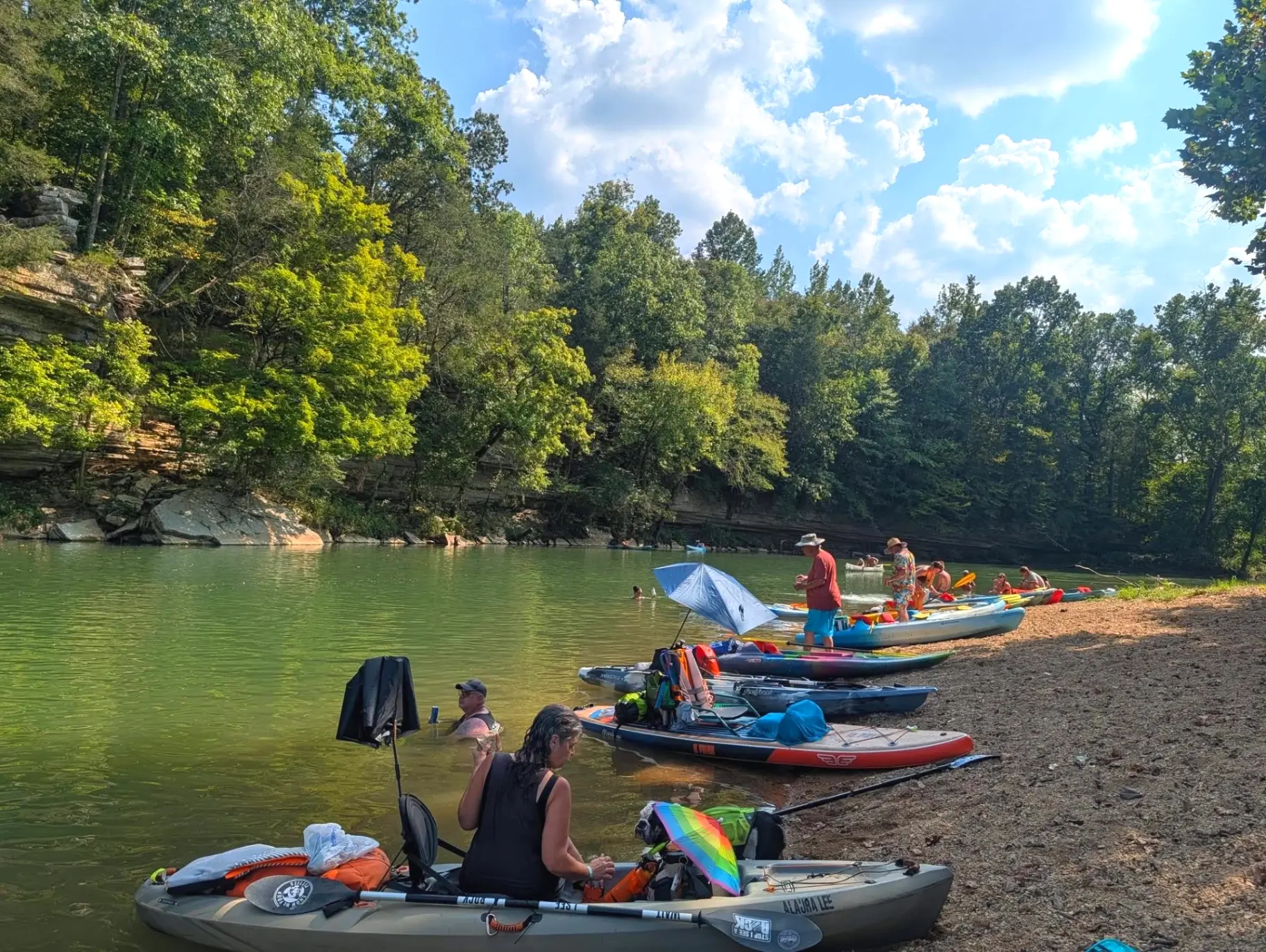 Kayaks and canoes pulled up on a gravel bar