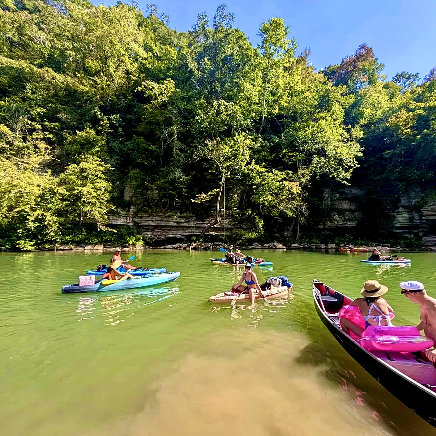 The group rafted up on paddleboards and canoes in emerald water