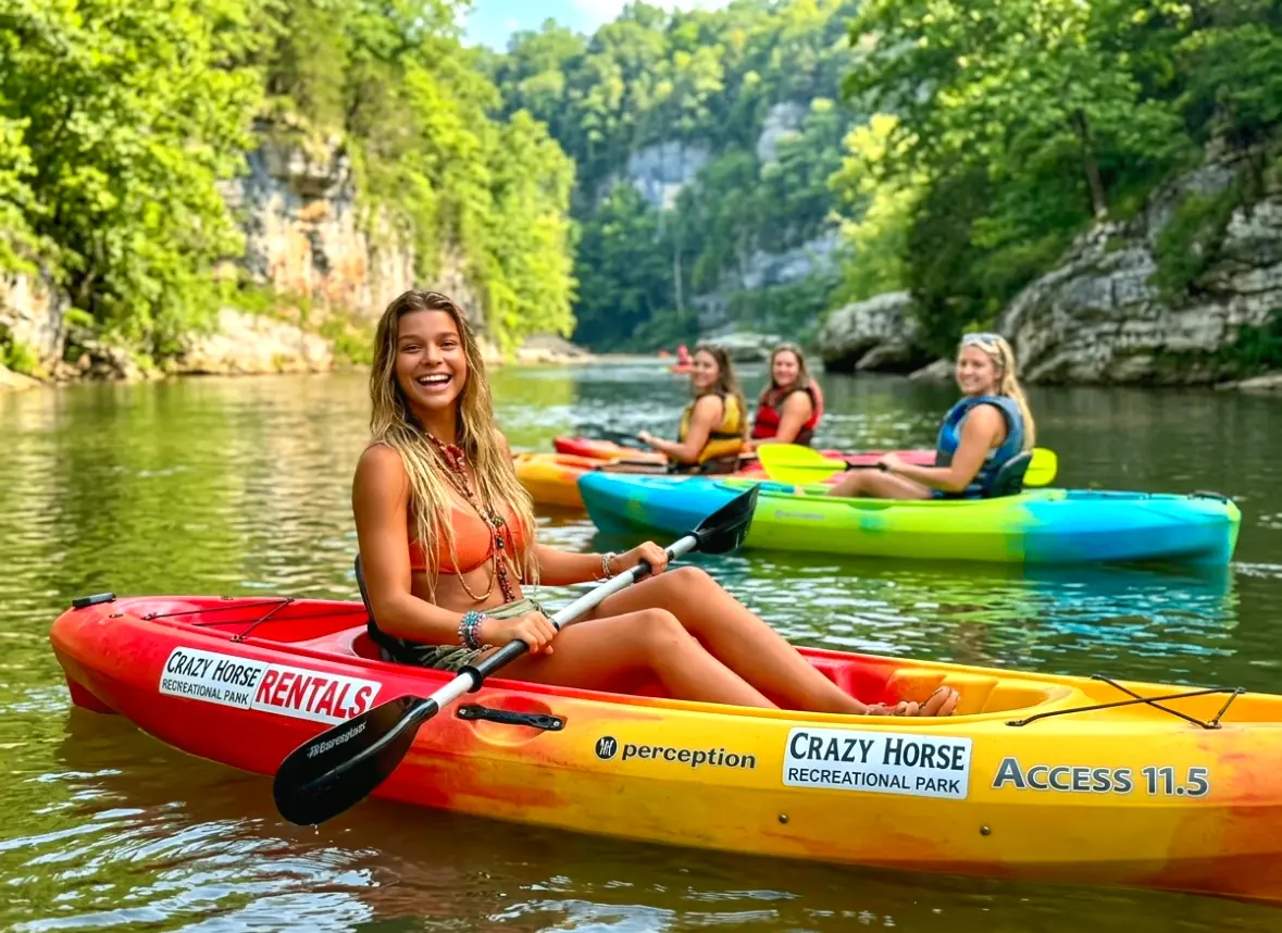 Friends paddling colorful Crazy Horse kayaks beneath the bluffs