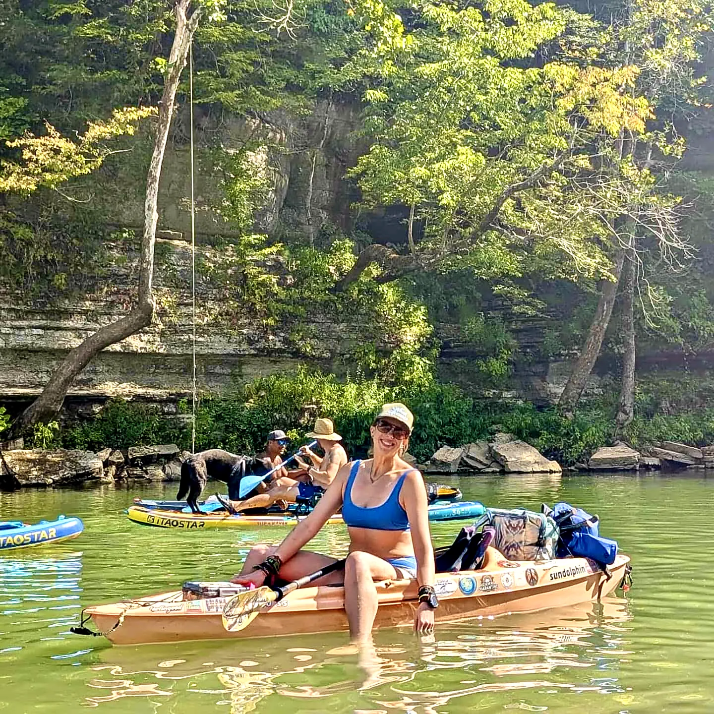 Rope swinging beside kayakers beneath the bluffs