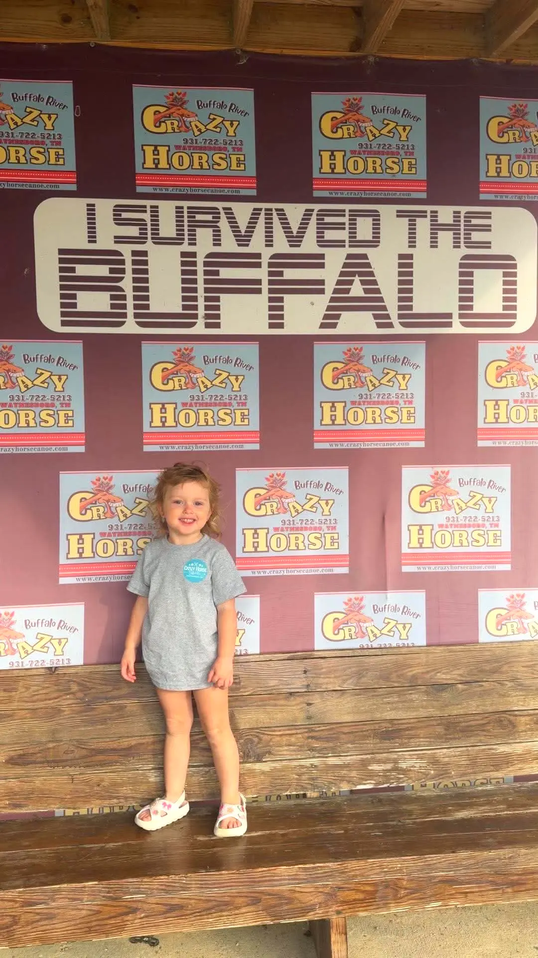 Little girl smiling in front of the I Survived the Buffalo sign
